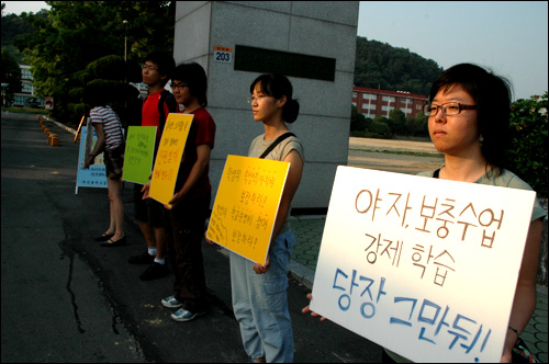 아수나로 회원들이 용마고 정문에서 피켓을 들고 서 있다.