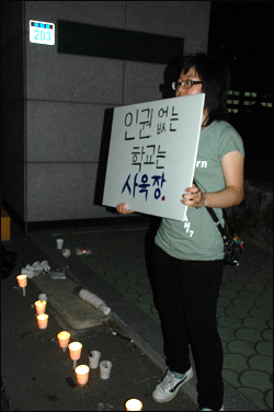 아수나로 한 회원이 용마고 정문 앞에 10일 밤 피켓을 들고 서 있다.