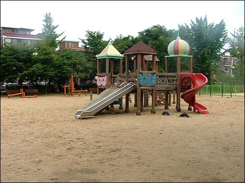 어린이 놀이터의 바닥이 모래로 되어있다.