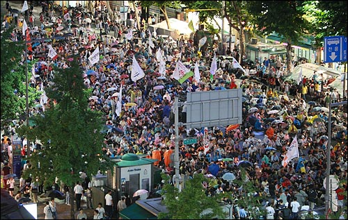 전대협 출신 시민들과 누리꾼들이 19일 저녁 서울 종로3가 도로 전 차선을 점거한 채 미국산 쇠고기 전면 재협상과 정부 정책에 항의하며 연좌농성을 벌이고 있다.