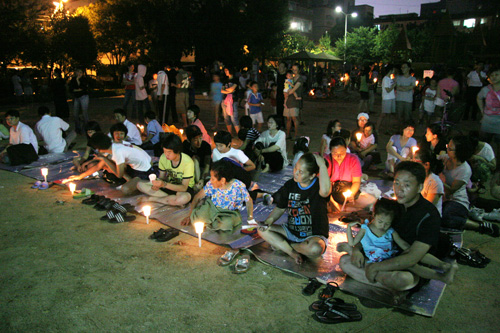 지난 22일 부평5동 부흥놀이공원에서는 진달래어린이도서관 주최로 '광우병 없는 우리동네를 위한 촛불 문화제'가 열렸다. 동네 주민들이 돗자리를 깔고 앉아 촛불문화제에 참석하고 있다.
