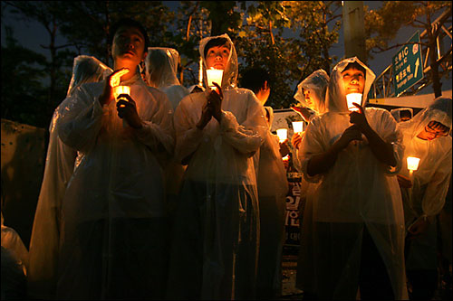 25일 저녁 서울 영등포 민주노총 앞에서 열린 촛불문화제에서 시민 200여명이 세찬 장맛비에도 촛불을 밝히고 있다. 