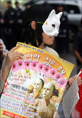 25일 저녁 서울 영등포 민주노총 앞에서 열린 촛불문화제에서 한 학생이 오는 30일 서울시 교육감 선거 가상 후보인 '캐발랄 젊은 후보 기호 0번 청소년'을 홍보하는 포스터를 들고 있다.
