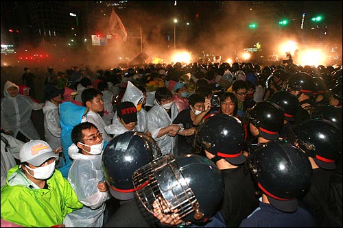 26일 밤 서울 종로 보신각 네거리에서 '미친소 미친교육 반대! 이명박 심판! 제80차 집중촛불문화제'에 참석했던 누리꾼과 시민들이 가두시위를 벌이는 가운데, 경찰이 소화기를 쏘며 강제해산에 나서고 있다.