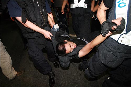 시민들을 강제해산 시키기 위해 몸싸움을 벌이던 한 경찰이 탈진해 동료들에 의해 들려 나오고 있다.