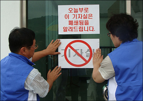 통영공무원노동조합 간부들이 제2기자실 폐쇄 안내문을 붙이고 있다.