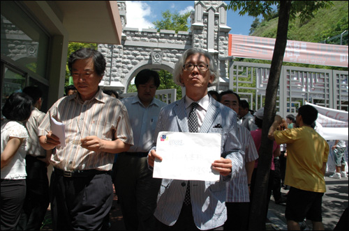 김한성 교수노조 위원장이 창신대학 정문 안으로 들어와 항의서한을 들고 걸어가고 있다.