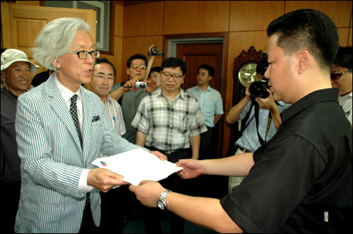 김한성 교수노조 위원장이 창신대학 학장실을 찾아 비서실 관계자한테 항의서한을 전달하고 있다.