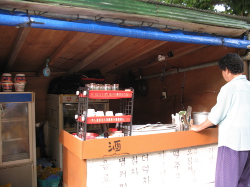 산을 오르는 사람에게 음료수와 간단한 스넥을 팔고 있다. 