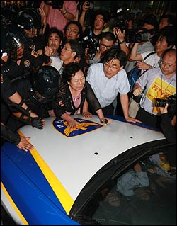 5일 저녁 서울 종로구 청계광장 앞에서 '부시 방한 반대' 촛불문화제에 참가한 한 시민이 경찰관 기동대대원들에게 강제연행되자 시민들이 순찰차를 가로 막고 있다.