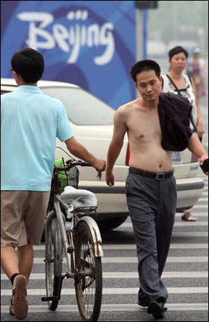 지난 7월 27일 중국 베이징 선수촌 인근 도로에서 한 행인이 웃통을 벗은채 길을 건너고 있다.