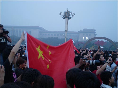  대형 오성홍기를 들어보이는 중국인들. "중국 화이팅", "중국잉, 일어나라"를 외치고 있다. 