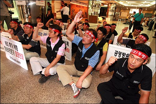 박승규 KBS노조 위원장(맨 오른쪽)과 간부들이 2008년 8월8일 오전 여의도 KBS본사에 들어온 사복경찰들을 내보낸 뒤 현관입구에 앉아 구호를 외치고 있다. 그러나 20분뒤 경찰은 수백명의 경찰병력을 KBS본관에 진입시켰다.