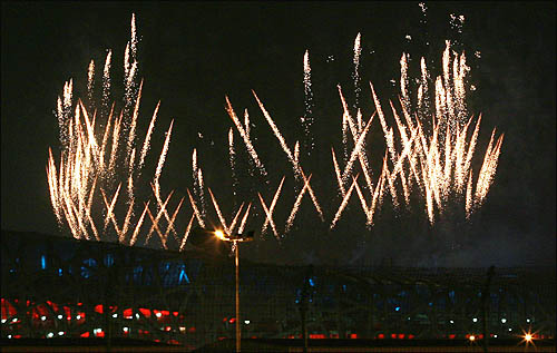  2008 베이징올림픽 개막식이 열린 8일 저녁 주경기장인 궈자티위창에서 개막을 알리는 폭죽이 터지며 밤 하늘을 물들이고 있다.