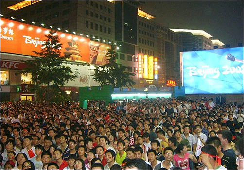  베이징의 번화가 왕푸징 거리에 수 만명의 시민들이 운집해, 올림픽 개막식 중계를 시청하고 있다.
