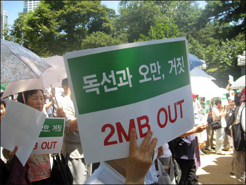 봉은사 시국법회에 참가한 한 신도가 '독선과 오만, 거짓, 2MB OUT' 피켓을 들고 시위를 벌이고 있다.