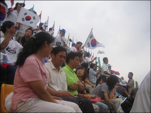  한국 응원단 사이에 앉아있는 중국 관중들
