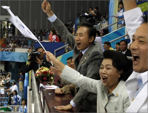 8월 9일 베이징 올림픽 여자 핸드볼 한국과 러시아의 경기에서 응원하는 이명박 대통령 내외. 이 대통령이 들고 응원한 태극기가 태극무늬 상하가 뒤바뀐 '거꾸로 태극기'로 밝혀져 논란이 됐다.