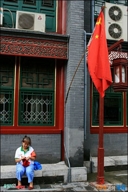 류리창에서 뜨개질을 하며 앉아있는 올림픽지원자 아주머니