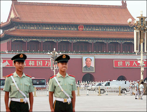 2008 베이징올림픽이 한창 열리고 있는 가운데 12일 오후 베이징 천안문 광장이 외국인 등 관광객들로 북적이고 있다. 만일의 사태에 대비해 배치된 공안 뒤에는 근대 중국의 상징 마오쩌둥의 대형 초상화가 걸려 있다. 