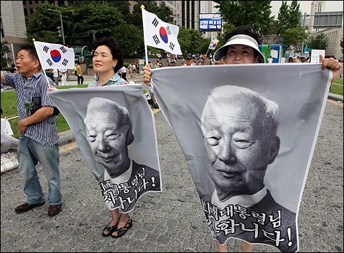  국민행동본부, 뉴라이트전국연합, 대한민국사랑회, 한국자유총연맹 등 보수단체회원들이 2008년 8월 15일 오전 서울 청계광장에서 열린 건국60주년 기념식에서 이승만 대통령의 사진과 태극기를 들어보이고 있다.