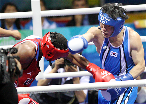  한국의 김정주(오른쪽)가 17일 저녁 베이징 공인체육관에서 열린 2008베이징올림픽 남자 복싱 웰터급(69kg) 8강전에서 미국의 드미트리어스 안드라이드 안면에 주먹을 날리고 있다.