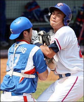  한국의 강민호 선수가 18일 베이징 우커송 야구장에서 열린 2008베이징올림픽 야구 예선 대만과의 경기에서, 2회말 1사 1,3루에서 대만의 리치셍이 내야땅볼을 쳤을 때 홈으로 달려든 펭첸민을 태그 아웃시키며 부딪히고 있다.