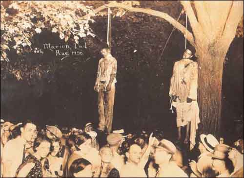 1930년에 백인들의 린치로 사망한 ‘흑인’ 토마스 쉽(Thomas Shipp)과 아브람 스미스(Abram Smith). 나무 밑에는 잘 차려입고 모자까지 챙겨 쓴 ‘백인’ 군중들이 의식에 참여하고 있다.