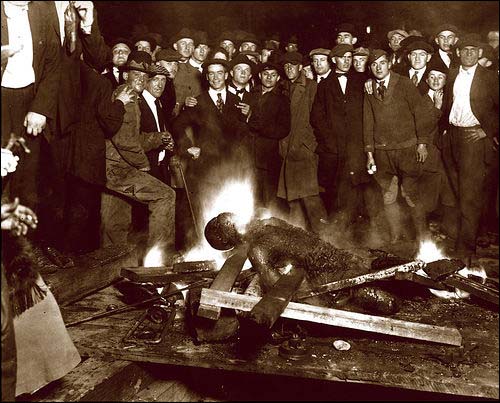 1919년에 백인들의 린치로 사망한 ‘흑인’ 윌리엄 브라운(William Brown)의 사진. 백인들이 기념사진 촬영을 위해 포즈를 취하고 있다.