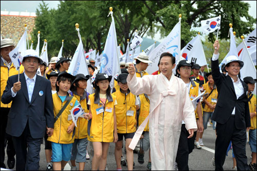  지난 15일 경복궁 앞 광장에서 열린 대한민국 건국60년 중앙경축식에 참석한 이명박 대통령이 청소년들과 함께 태극기를 앞세우고 시청 앞까지 행진하고 있다. 