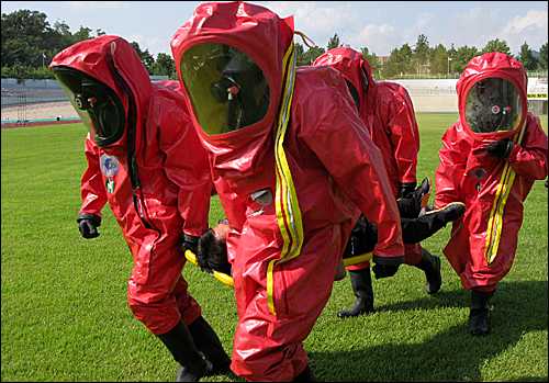 충북 음성군 종합운동장에서 실시된 '공공시설 화학전 테러대비 합동 시범훈련'에서 군부대 요원들이 화학가스에 노출된 피해자를 옮기고 있다. 