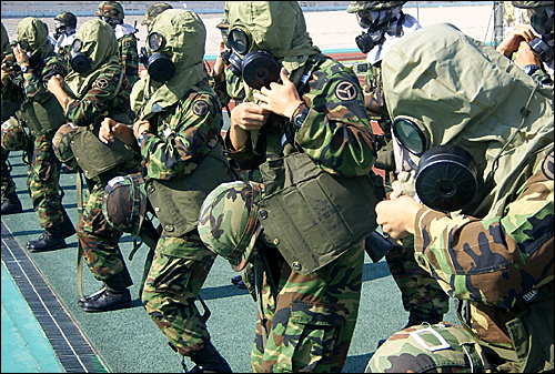 군부대 요원들이 화학가스가 살포됐을 때 착용하는 방독면 착용 시범을 선뵈고 있다.