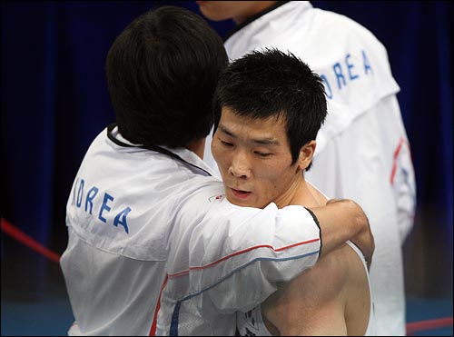  한국의 양태영이 19일 오후 베이징 국가체육관에서 열린 남자체조 평행봉 결승전에서 메달권을 벗어나자 코치진이 위로를 해주고 있다.
