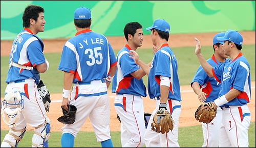  한국 선수들이 20일 베이징 우커송 야구장에서 열린 2008베이징올림픽 야구 예선 네덜란드와의 경기에서 8회 10-0 콜드게임으로 승리한 뒤 팀동료들과 하이파이브를 하고 있다.