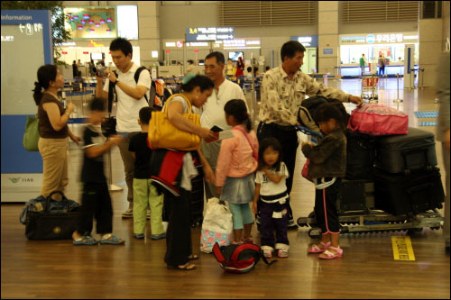 두 나홀로 입학생 가족이 인천국제공항에서 출국 수속을 밟고 있다.