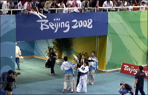  21일 베이징 올림픽 여자태권도 57kg급에서 금메달을 따낸 임수정 선수가 관중석에서 던져준 태극기를 받기 전에 자원봉사자가 낚아챘다.