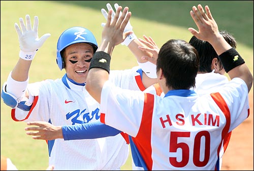 한국의 이승엽이 22일 베이징 우커송 야구장에서 열린 2008베이징올림픽 야구 준결승 일본과의 경기에서 8회말 1사 1루 타석때 역전 2점 홈런을 친뒤 더그아웃에서 팀동료들과 하이파이브를 하고 있다.