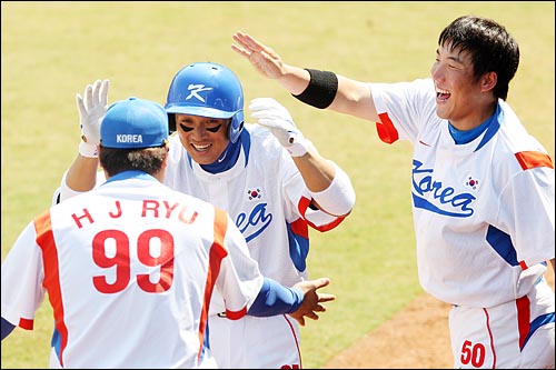  한국의 이승엽이 22일 베이징 우커송 야구장에서 열린 2008베이징올림픽 야구 준결승 일본과의 경기에서 8회말 1사 1루 타석때 역전 2점 홈런을 친뒤 더그아웃에서 팀동료들의 축하를 받고 있다.