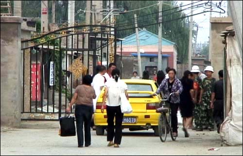  21일 오후 중국 베이징 외곽 나이즈팡 어귀에 설치된 철창문에서 보안원들이 주민들의 신분증을 검사하고 있다.