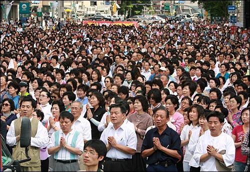 '헌법파괴·종교차별 이명박 정부 규탄 범불교도대회'에서 참가자들이 광장을 가득 메우면서 수천명의 참석자들이 광장 주변 도로에서 대형 모니터를 보며 기도를 하고 있다. 