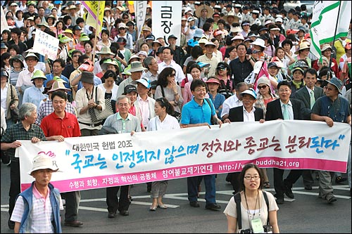 참여불교재가연대 회원들이 '국교는 인정되지 않으며, 정치와 종교는 분리된다'는 '헌법20조'의 내용을 적은 현수막을 들고 행진하고 있다.