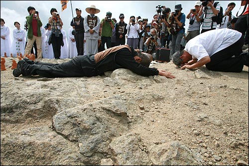 수경스님과 문규현 신부가 연대발언을 마친 김성근 원불교 교무(오른쪽)와 절을 하고 있다.