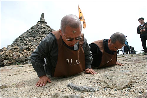 4일 오후 지리산 노고단에서 열린 '사람의 길, 생명의 길, 평화의 길'을 찾아 나서는 오체투지 순례 출발행사에서 오체투지한 뒤 일어서는 수경스님과 문규현신부 이마에 작은 돌들이 붙어 있다.