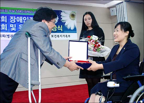 한국장애인인권포럼 이범재 대표로부터 우수의원 상을 받는 서울시의회 나은화 의원