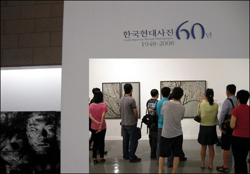 한국현대사진60년전 전시장 입구. 구성연(1970~)의 '팝콘시리즈'(2007) 작품 앞에 관객들. 구성연의 팝콘시리즈를 '현대판사군자'라고도 한다