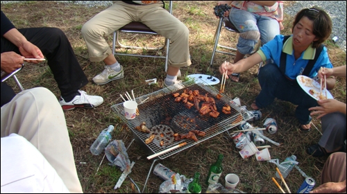 동네사람들이 친지들과 삼삼오오 모여 부녀회에서 준비한 아나고양념구이를 구워 먹고 있다.