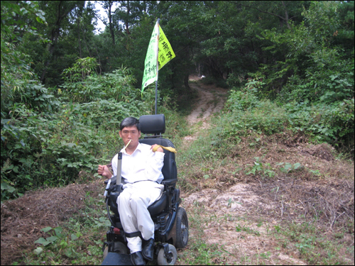 전동 휠체어를 탄 최창현씨가 산에서 내려오고 있다.