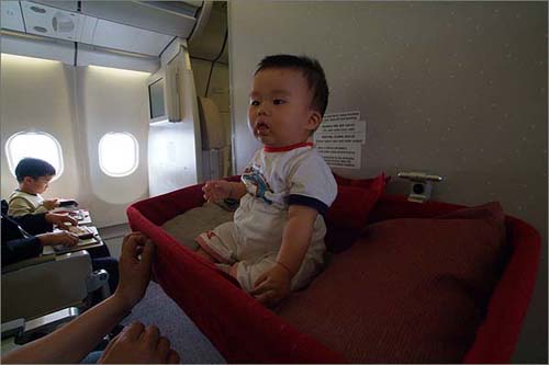 비행기에서 제공해준 아기침대에 앉은 둘째 유찬이. 만 2살이 안돼 공짜 손님이다. 이코노미석 맨 앞자리는 상대적으로 공간이 넓어 이코노미의 '퍼스트 클래스'인 셈이다. 이런 자리를 얻은 건 어린아이와 함께 떠나는 여행의 보너스다.