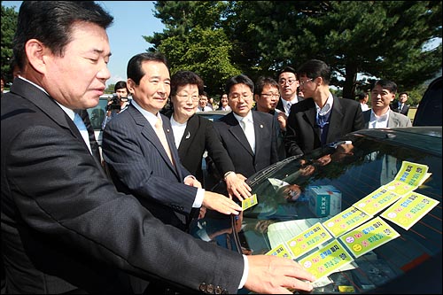  민주당 정세균 대표, 김진표, 김민석 최고위원 등 지도부들이 1일 오전 서울 여의도 국회의원회관에서 열린 '종부세 개악저지 및 부가세 인하 결의대회'를 마친뒤 자동차에 종부세 완화를 반대하는 스티커를 붙이고 있다.