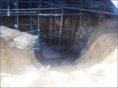 금정굴 안으로 들어서자 철제 빔 한가운데 유골을 발굴한 장소가 천막 속에 보인다